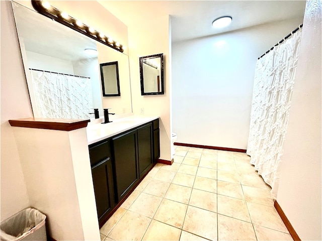 bathroom with tile patterned flooring, vanity, and toilet