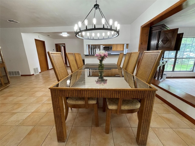 dining area with light tile patterned floors and a chandelier