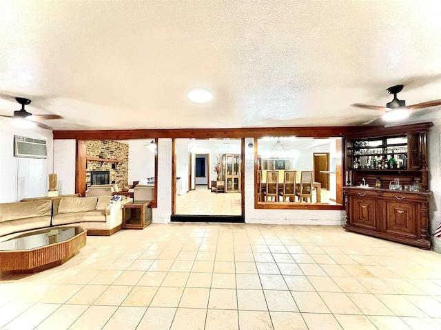 tiled living room featuring a brick fireplace, ceiling fan, a wall mounted AC, and a textured ceiling