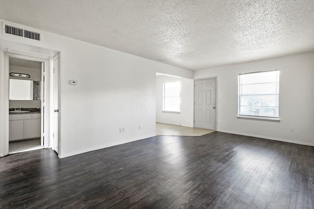 empty room featuring dark hardwood / wood-style floors and a textured ceiling