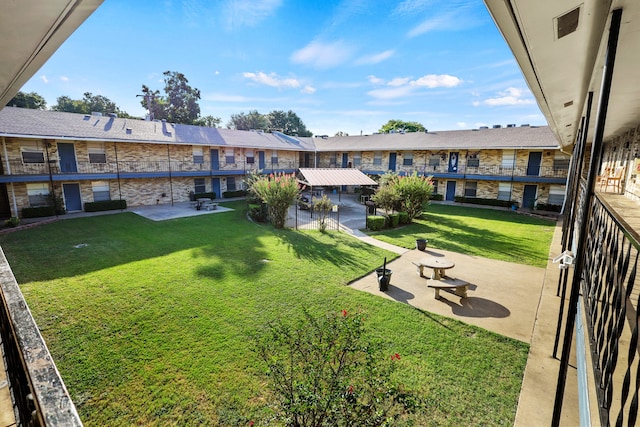 view of property's community featuring a yard and a patio area