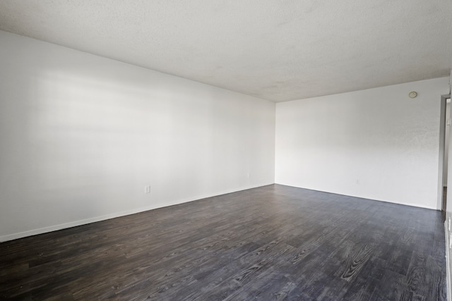 unfurnished room with dark hardwood / wood-style floors and a textured ceiling