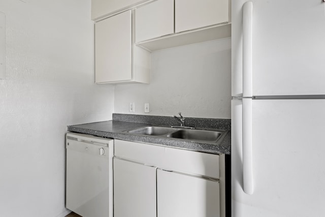 kitchen featuring white appliances, white cabinets, and sink