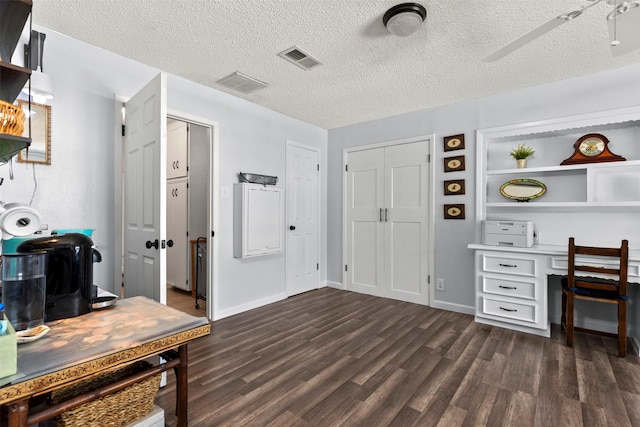 office space with ceiling fan, dark wood-type flooring, and a textured ceiling