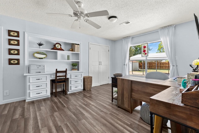 office area featuring built in shelves, ceiling fan, dark hardwood / wood-style floors, and a textured ceiling