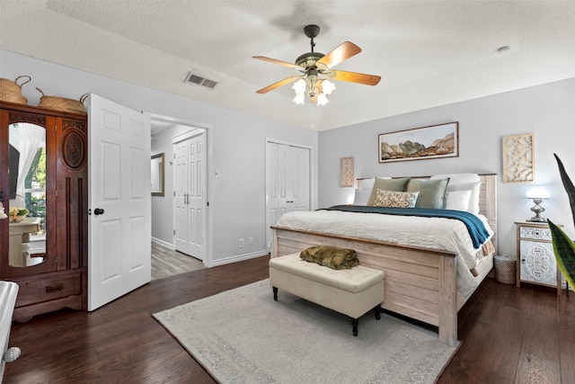 bedroom with ceiling fan, dark hardwood / wood-style flooring, and a textured ceiling