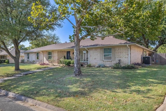 ranch-style house featuring a front lawn and cooling unit