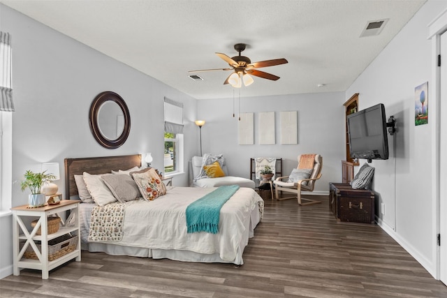 bedroom featuring ceiling fan, dark hardwood / wood-style flooring, and a textured ceiling