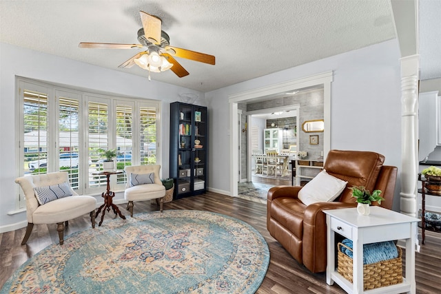 living area with a textured ceiling, ceiling fan, and dark wood-type flooring