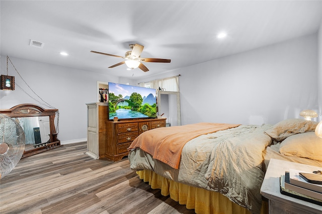 bedroom with ceiling fan and hardwood / wood-style flooring