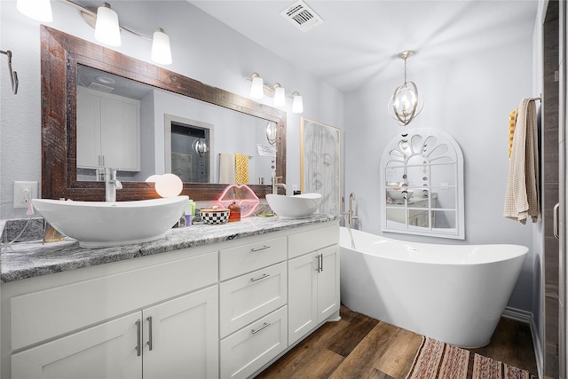 bathroom featuring wood-type flooring, vanity, and a tub