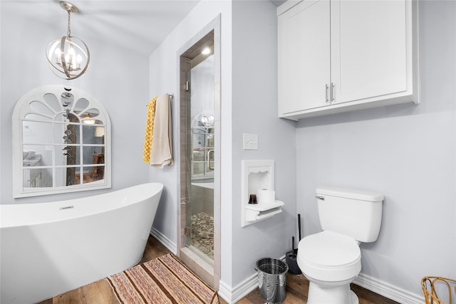 bathroom with hardwood / wood-style floors, toilet, shower with separate bathtub, and an inviting chandelier