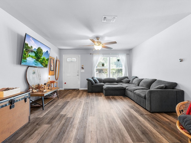 living room with ceiling fan and dark wood-type flooring