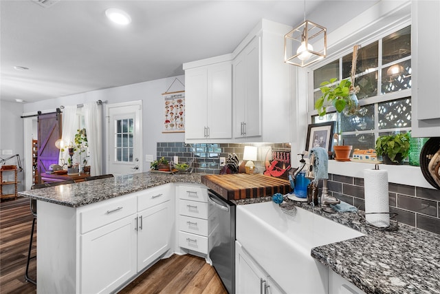 kitchen featuring white cabinets, a barn door, and kitchen peninsula