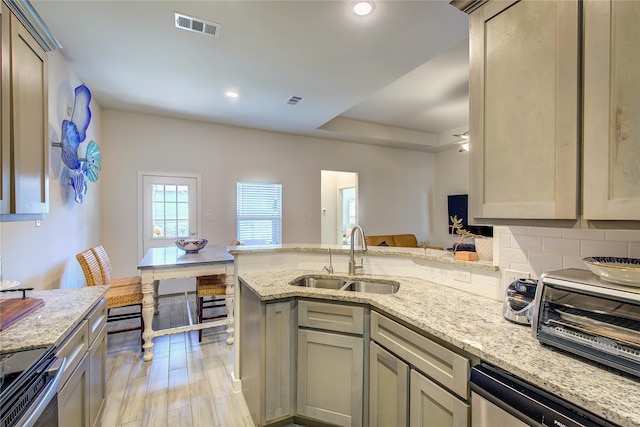 kitchen featuring light stone countertops, sink, stainless steel appliances, and light hardwood / wood-style flooring