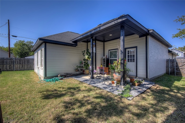 back of house featuring a patio and a yard