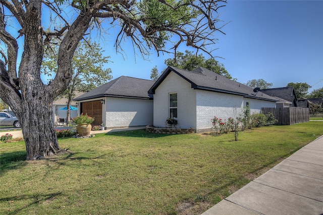 view of side of home with a garage and a lawn