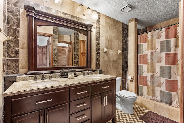 bathroom with toilet, a shower with curtain, tile walls, vanity, and a textured ceiling