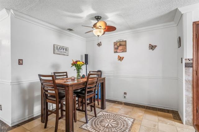 dining room featuring ceiling fan, ornamental molding, and a textured ceiling