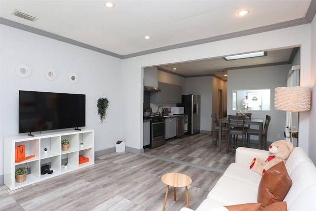 living room with crown molding and light hardwood / wood-style flooring