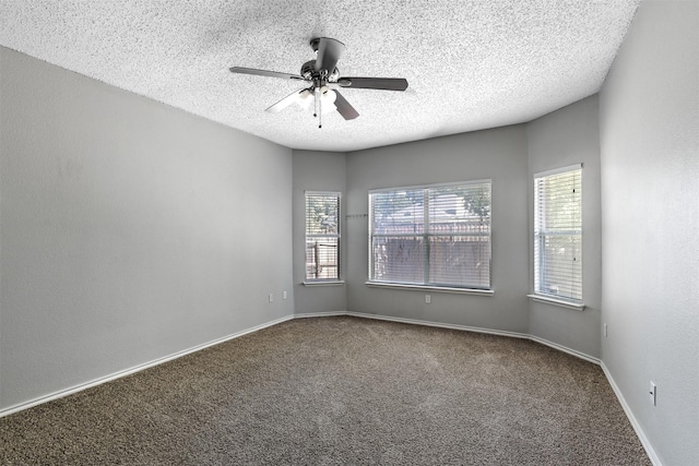 carpeted empty room with ceiling fan, plenty of natural light, and a textured ceiling