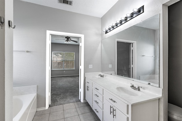 bathroom with tile patterned floors, a textured ceiling, vanity, a bathing tub, and ceiling fan