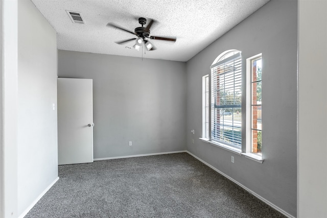 carpeted spare room featuring ceiling fan and a textured ceiling