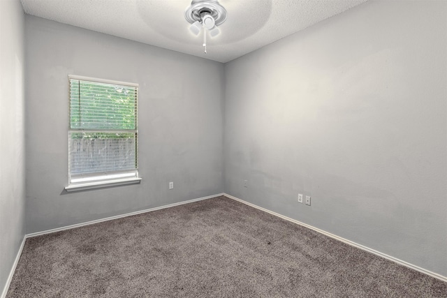 empty room with dark colored carpet, a textured ceiling, and ceiling fan