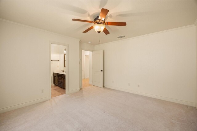 unfurnished bedroom featuring ornamental molding, connected bathroom, light colored carpet, and ceiling fan