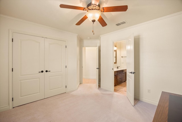 unfurnished bedroom with ornamental molding, light colored carpet, ceiling fan, and a closet