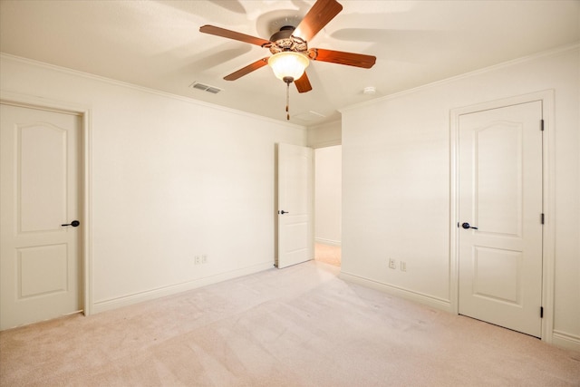 unfurnished bedroom featuring ceiling fan, visible vents, crown molding, and light colored carpet