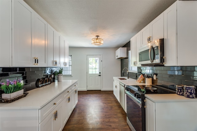 kitchen with sink, stainless steel appliances, white cabinetry, and tasteful backsplash