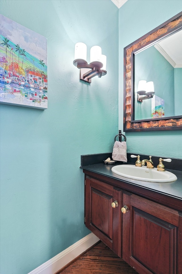 bathroom featuring hardwood / wood-style floors, crown molding, and vanity