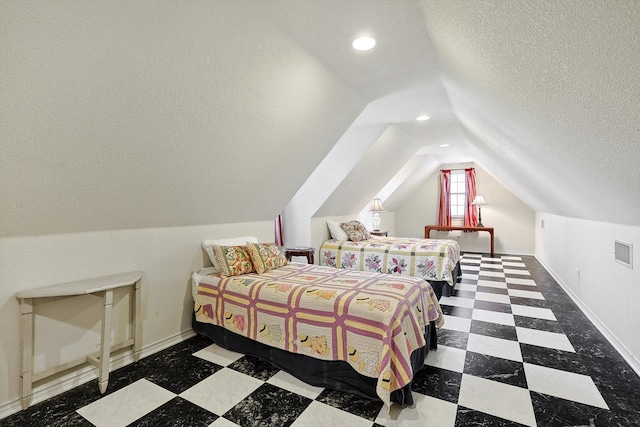 bedroom with a textured ceiling and vaulted ceiling