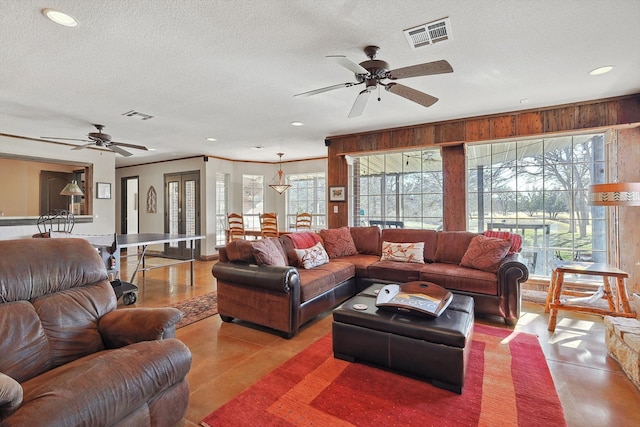 living room featuring ceiling fan and a textured ceiling