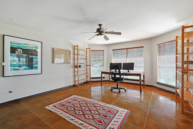 tiled home office with ceiling fan and a textured ceiling