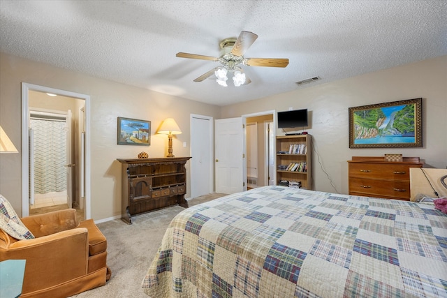 carpeted bedroom featuring ceiling fan and a textured ceiling