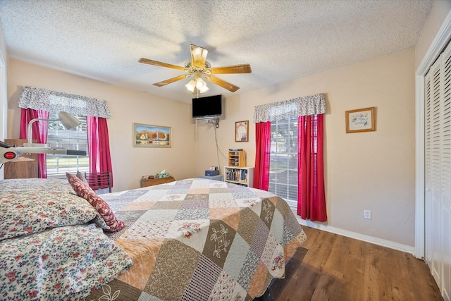 bedroom with a closet, ceiling fan, wood-type flooring, and a textured ceiling