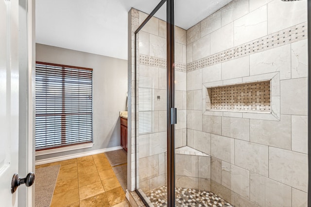 bathroom featuring a shower with door and vanity