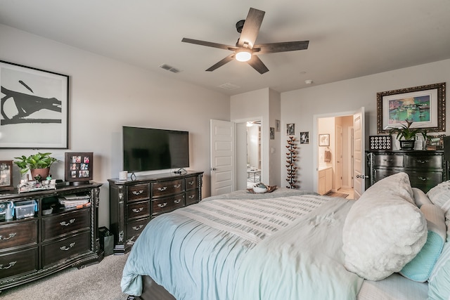 bedroom with connected bathroom, light colored carpet, and ceiling fan