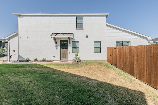 back of house featuring a lawn