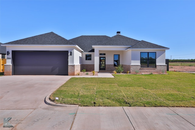 view of front of property featuring a garage and a front lawn