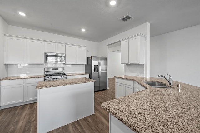 kitchen with a center island, dark hardwood / wood-style floors, sink, white cabinetry, and appliances with stainless steel finishes