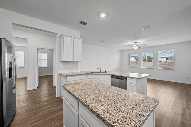 kitchen featuring white cabinets, stainless steel appliances, dark wood-type flooring, and a kitchen island