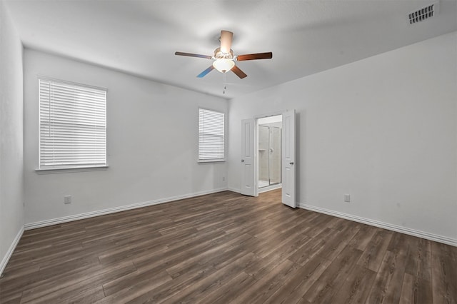 empty room with ceiling fan and dark hardwood / wood-style flooring