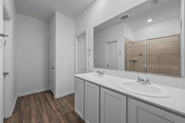 bathroom with a tile shower, hardwood / wood-style floors, and vanity