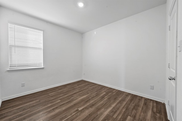 empty room featuring dark hardwood / wood-style flooring and a wealth of natural light