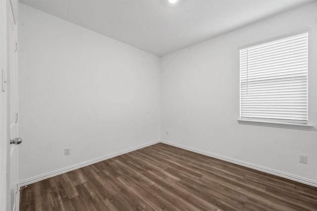 empty room with dark hardwood / wood-style flooring