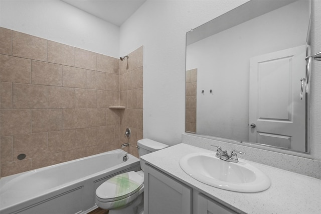 full bathroom with tiled shower / bath, vanity, and toilet