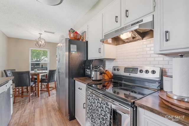 kitchen featuring white cabinetry, stainless steel appliances, light wood-type flooring, and wood counters